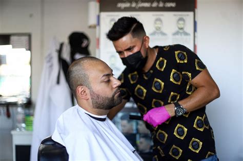 Joe Santibáñez y Gilberth Guere realizando cortes de pelo gratuitos en una actividad social.