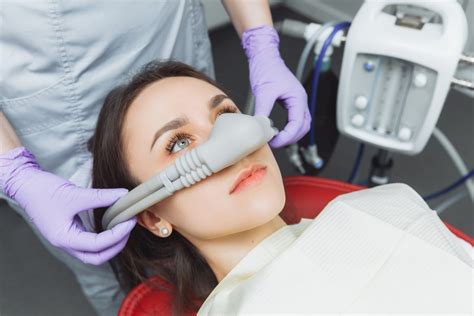 Paciente con mascarilla nasal de óxido nitroso en silla dental