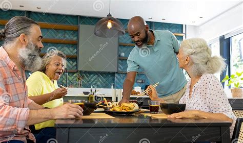 Grupo de amigos mayores compartiendo una comida en un espacio común de cohousing
