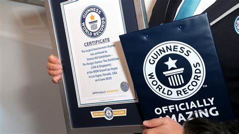 Robert Carmona posando con sus certificados oficiales de Guinness World Records